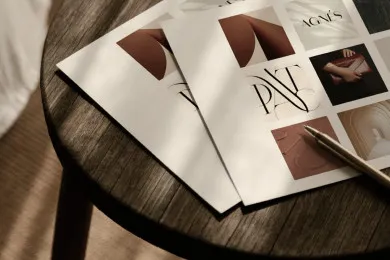 Materiały brandingowe – wizytówki i karty „PAT” i „AGNES” – na okrągłym taborecie z ciemnego drewna